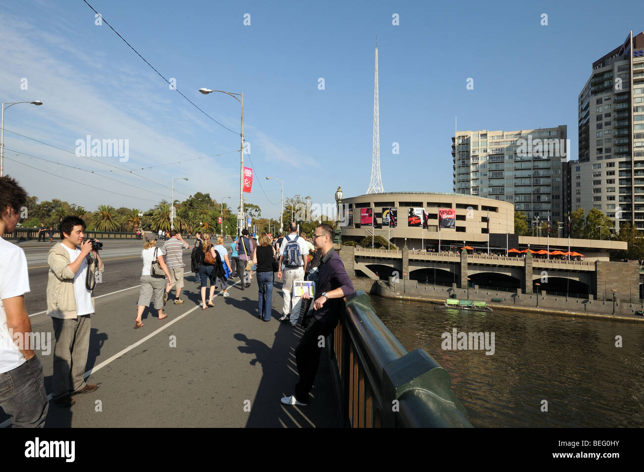 Young men tourists photograph each other on Princes Bridge over Yarra River Melbourne Australia Stock Photo