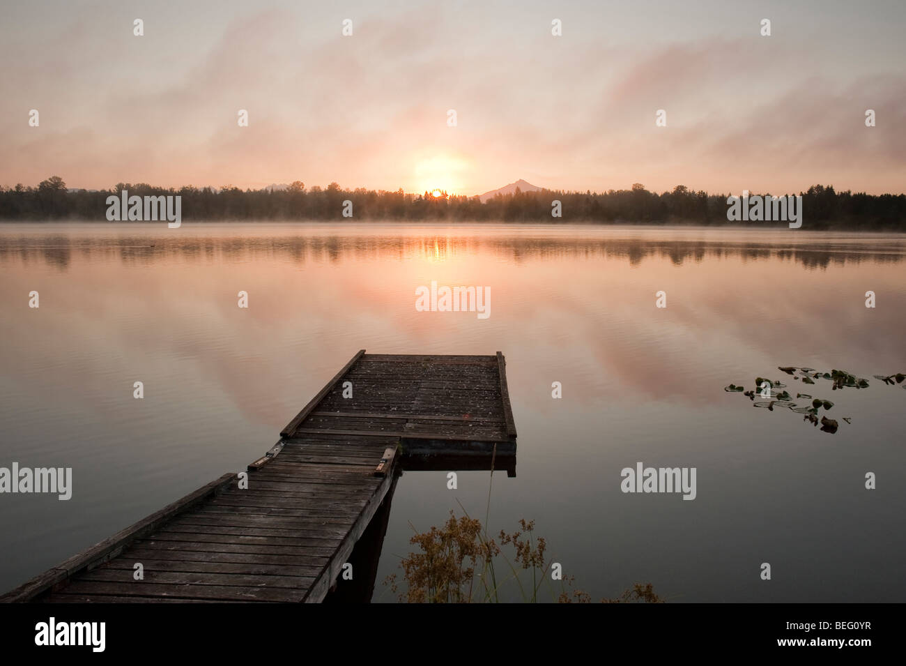 Sunrise at Lake Cassidy in fog with Mount Pilchuck and dock in