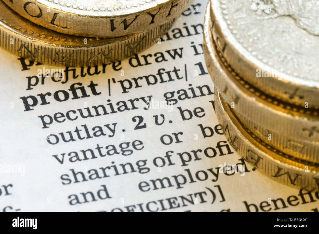 Close up of English dictionery definition of word profit with sterling £1 coins stacked to the side Stock Photo