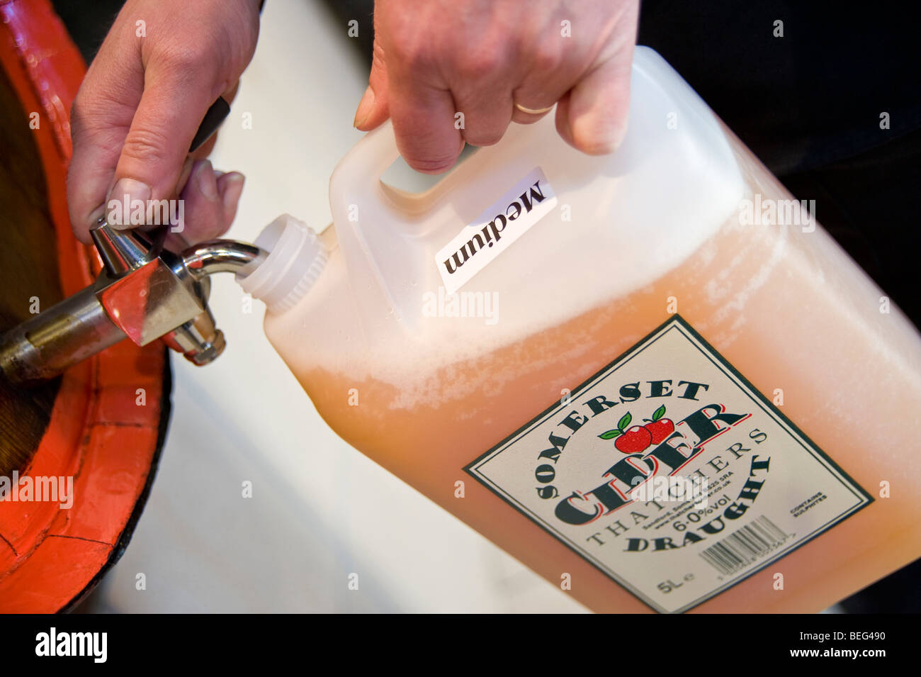 Filling a plastic container with Cider at Thatchers Cider, Thatchers Cider Farm. Sandford, North Somerset, England Stock Photo