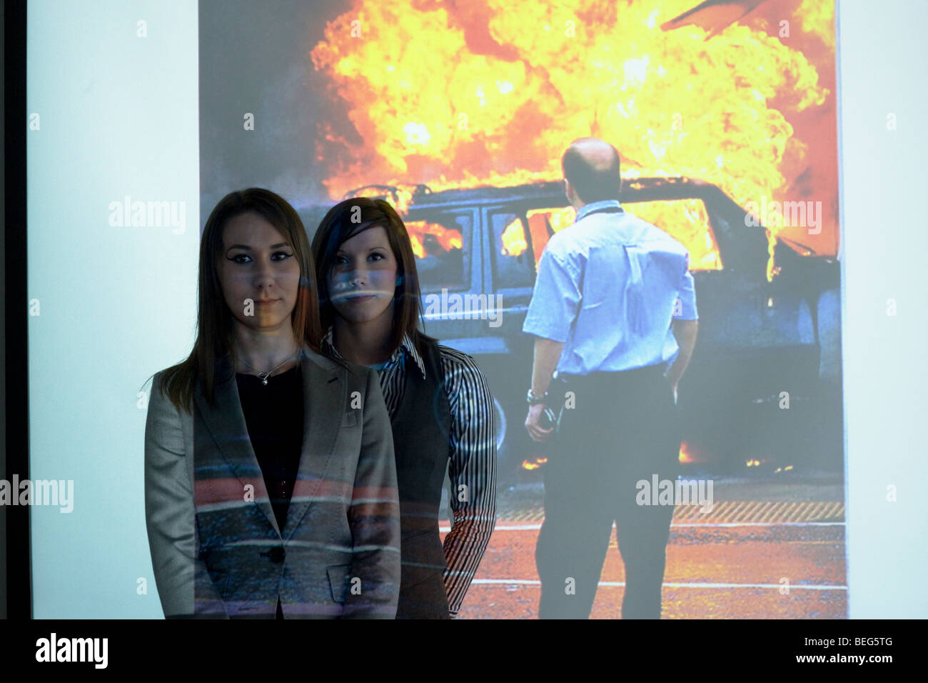 Two female BAA security instructors stand in front of a Powerpoint image showing the Glasgow airport terrorist attack. Stock Photo