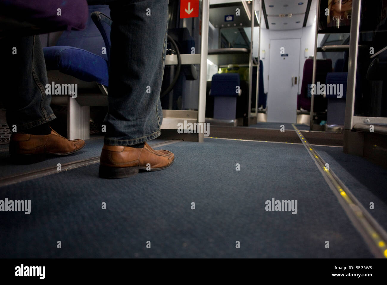 A passenger's leg is seen on the floor of a Heathrow Express train between terminals at Heathrow Airport. Stock Photo