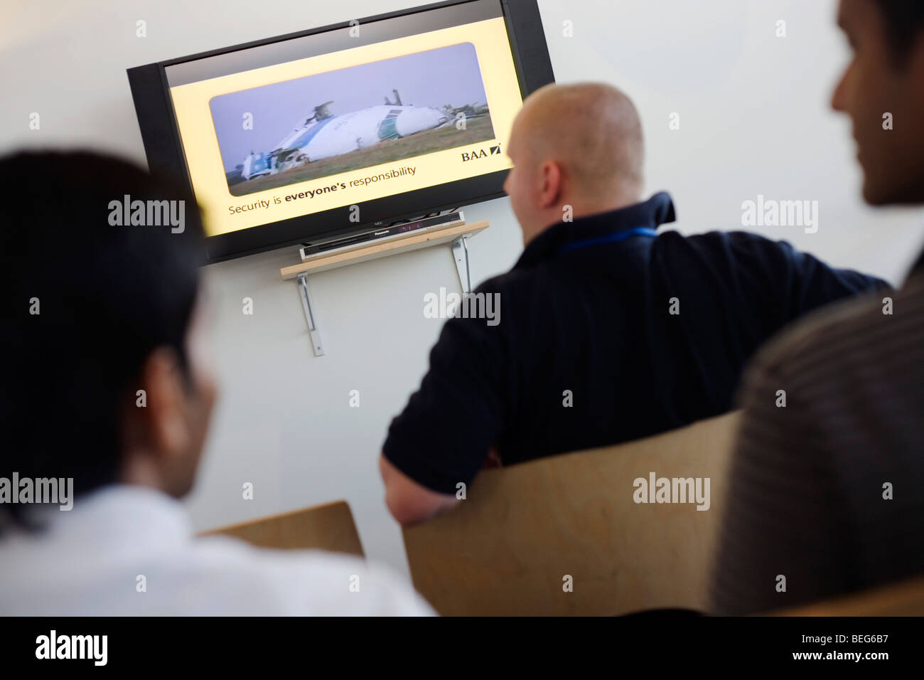 BAA staff watching security awareness film while awaiting issue of security passes at Heathrow airport. Stock Photo