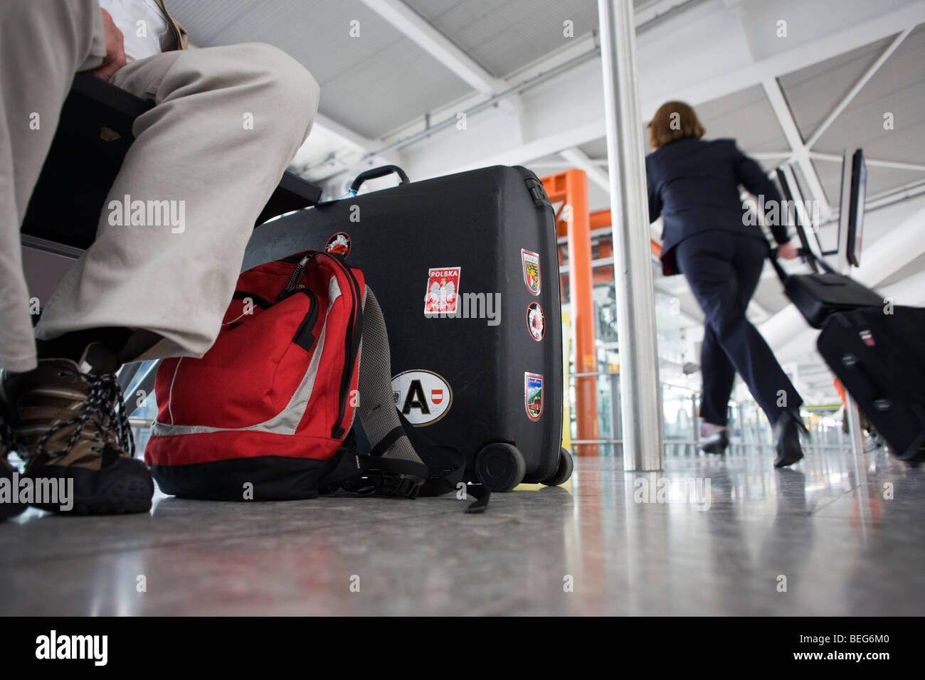 Passenger's baggage and rushing airline employee at Heathrow airport's