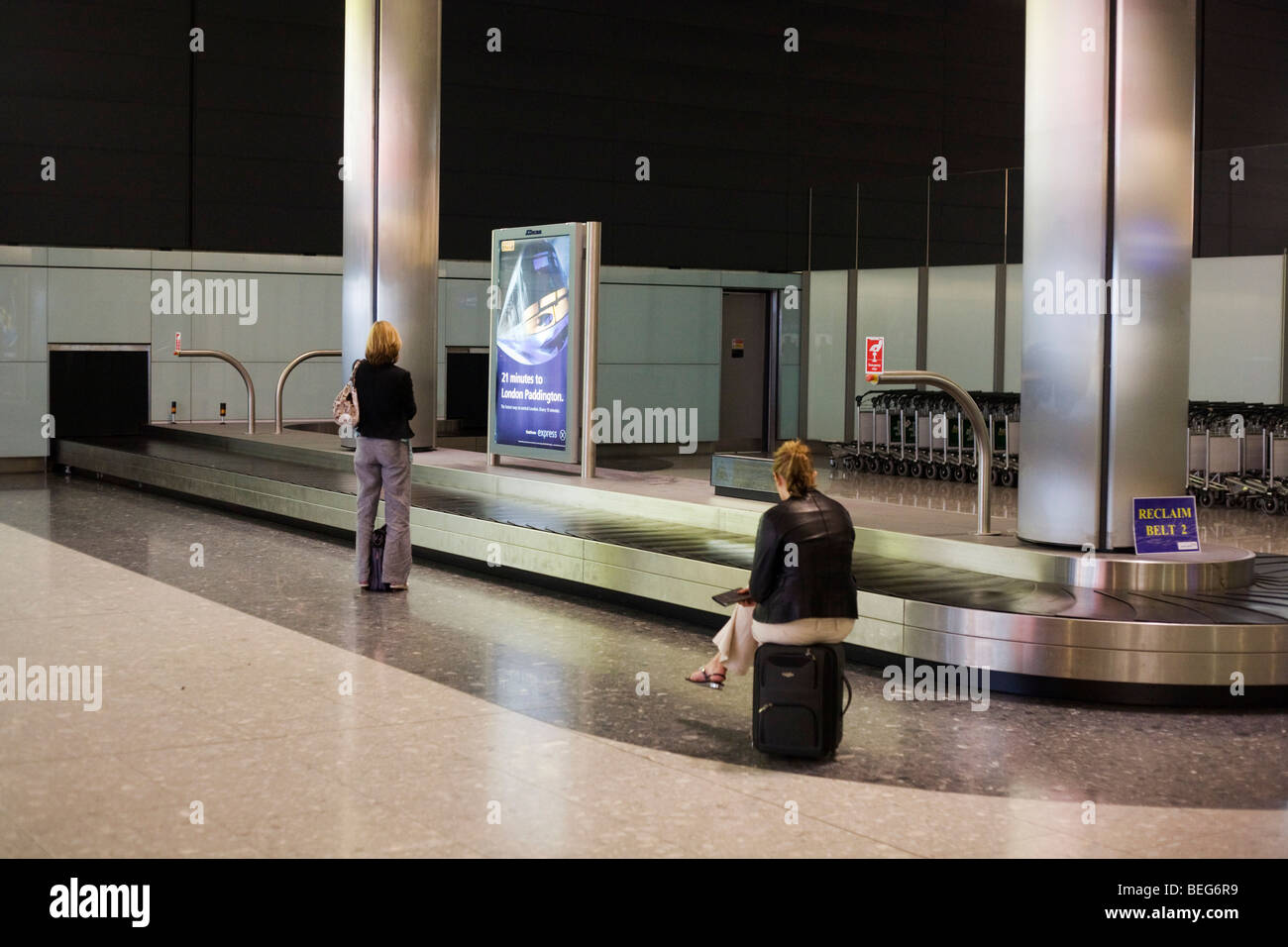 Last ladies awaiting their luggage from domestic baggage reclaim carousel at Heathrow's Terminal 5. Stock Photo
