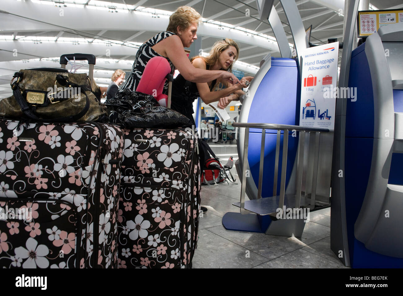 Departing passengers use British Airways self-service check-in kiosks at Heathrow Airport's Terminal 5. Stock Photo