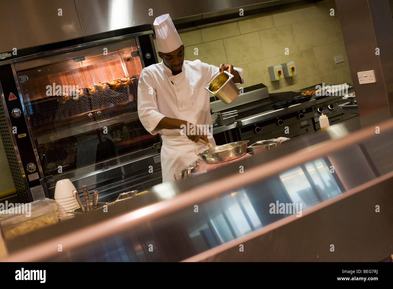 A chef pours liquids in the kitchens at the Vivre restaurant in Sofitel. Stock Photo