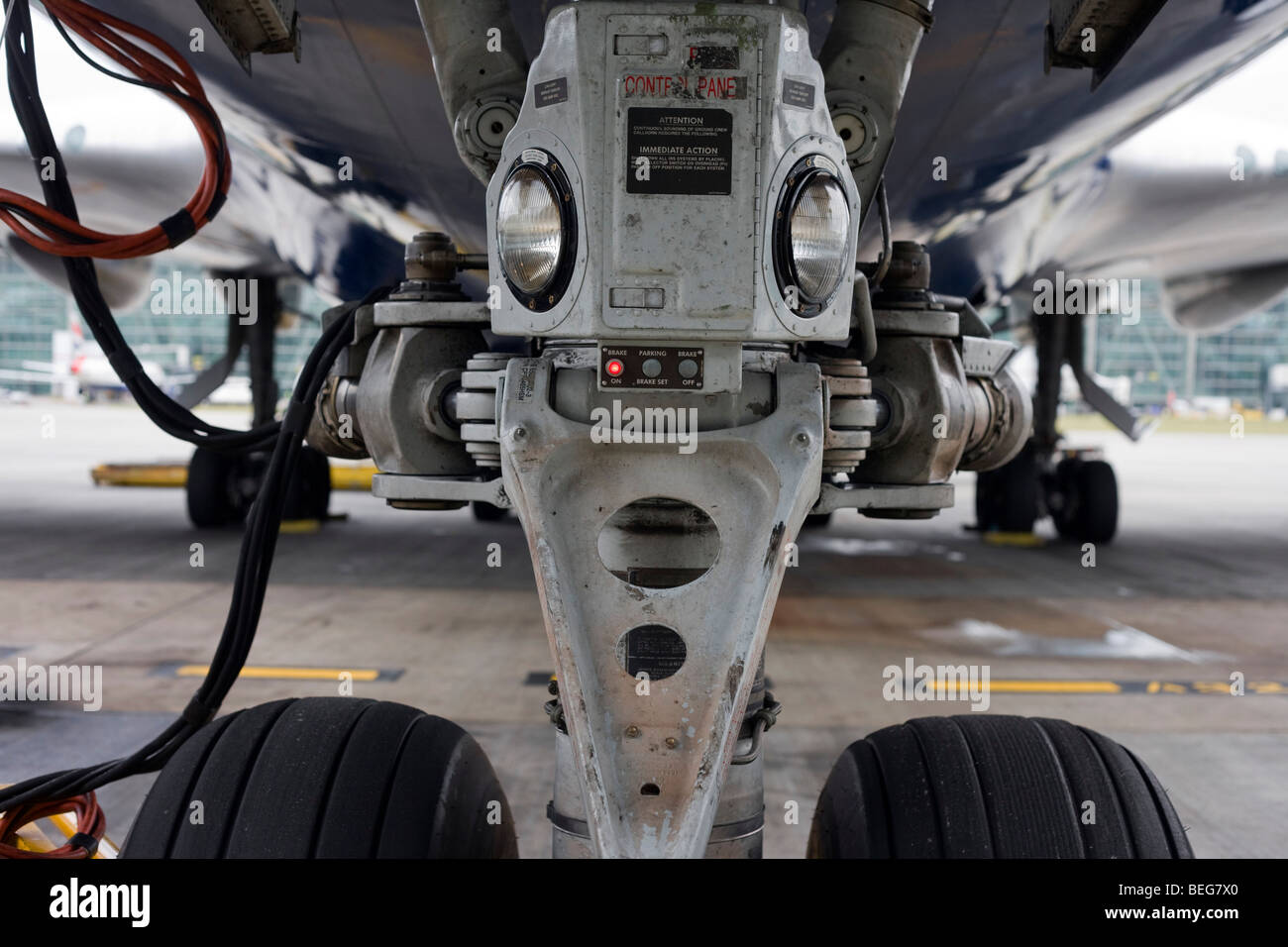A close-up detail of a Boeing 747 main nosewheel and landing lights during the aircraft's turnaround at Heathrow Airport. Stock Photo