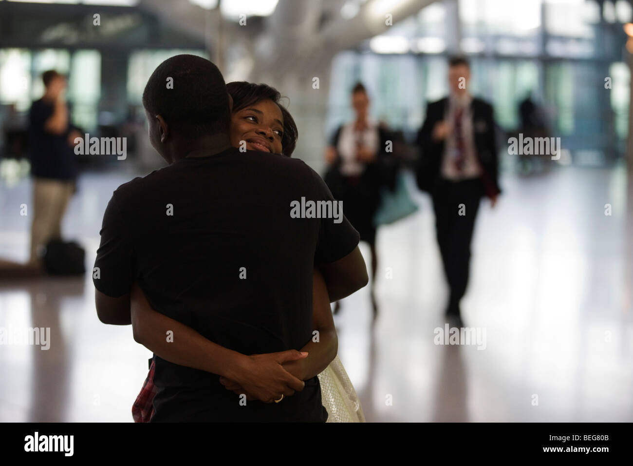 A departing lover hugs her boyfriend farewell before her long-haul flight in the Departures concourse at Heathrow Airport's T5 Stock Photo