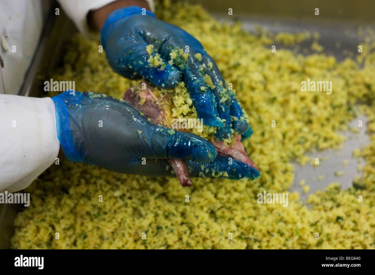 A chef coats Welsh Lamb cutlets in breadcrumbs destined for airline meals at Gate Gourmet at Heathrow Airport. Stock Photo