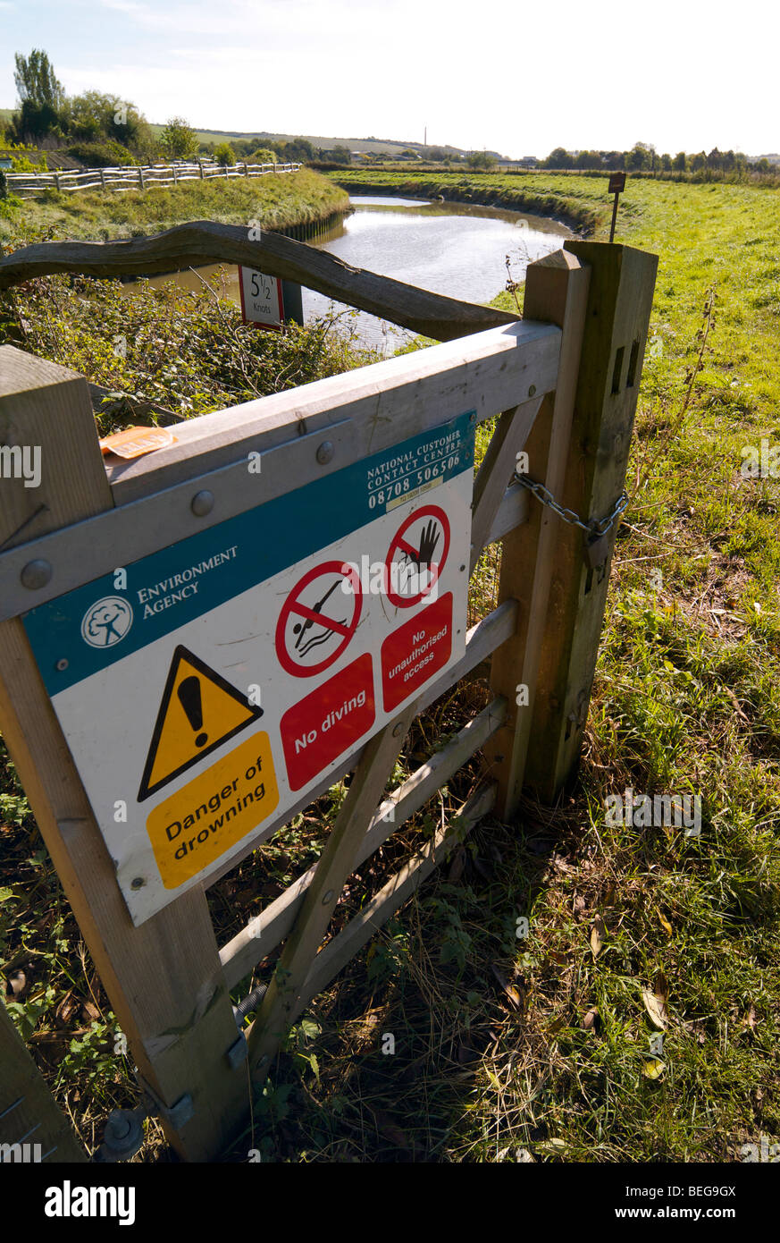 Environmental Agency warning notices beside a riverbank Stock Photo