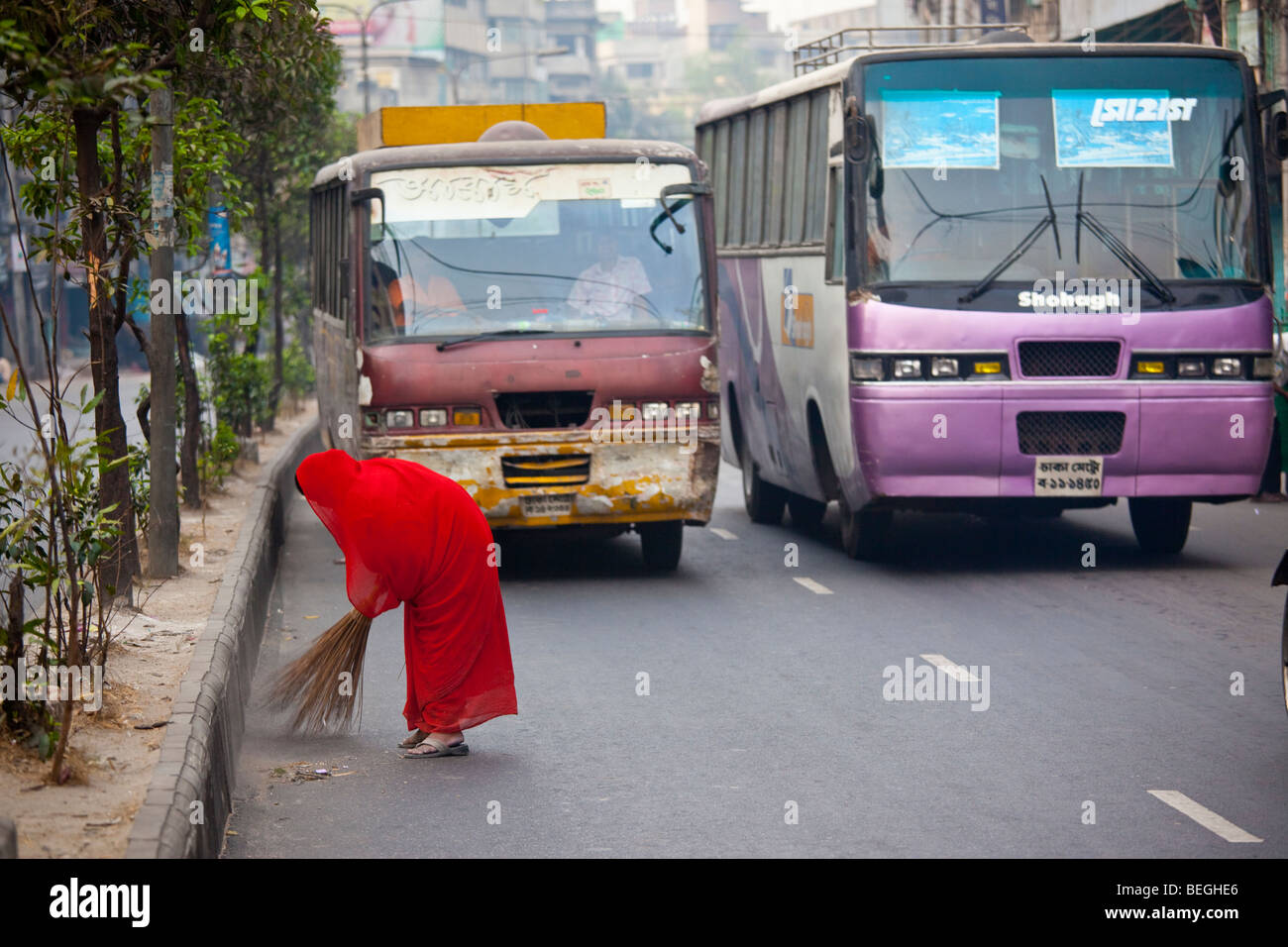 Woman sweeping the street in Dhaka Bangladesh Stock Photo