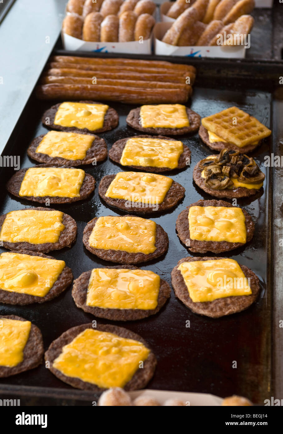 Cheese burgers frying on grill Blackpool Stock Photo