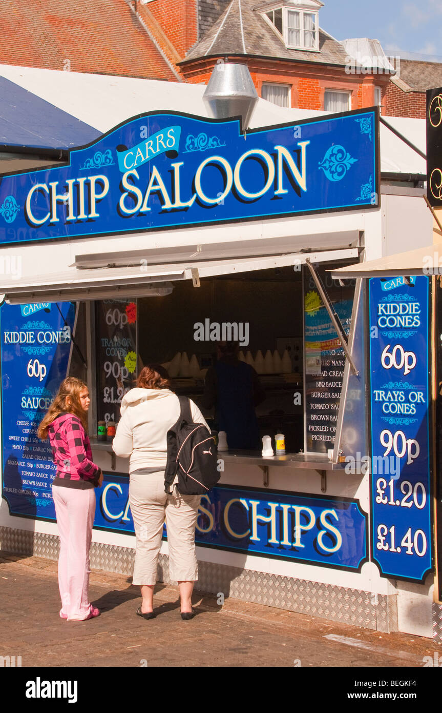 People eating chips from a chip stall ( carrs chip saloon ) at the market in Great Yarmouth