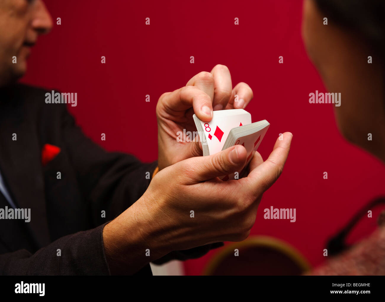 A close up magician doing card tricks at a wedding reception party, UK Stock Photo