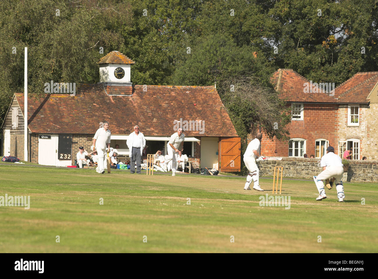 Lurgashall village green sees players participating in a game of cricket on a warm sunny autumn day. Stock Photo