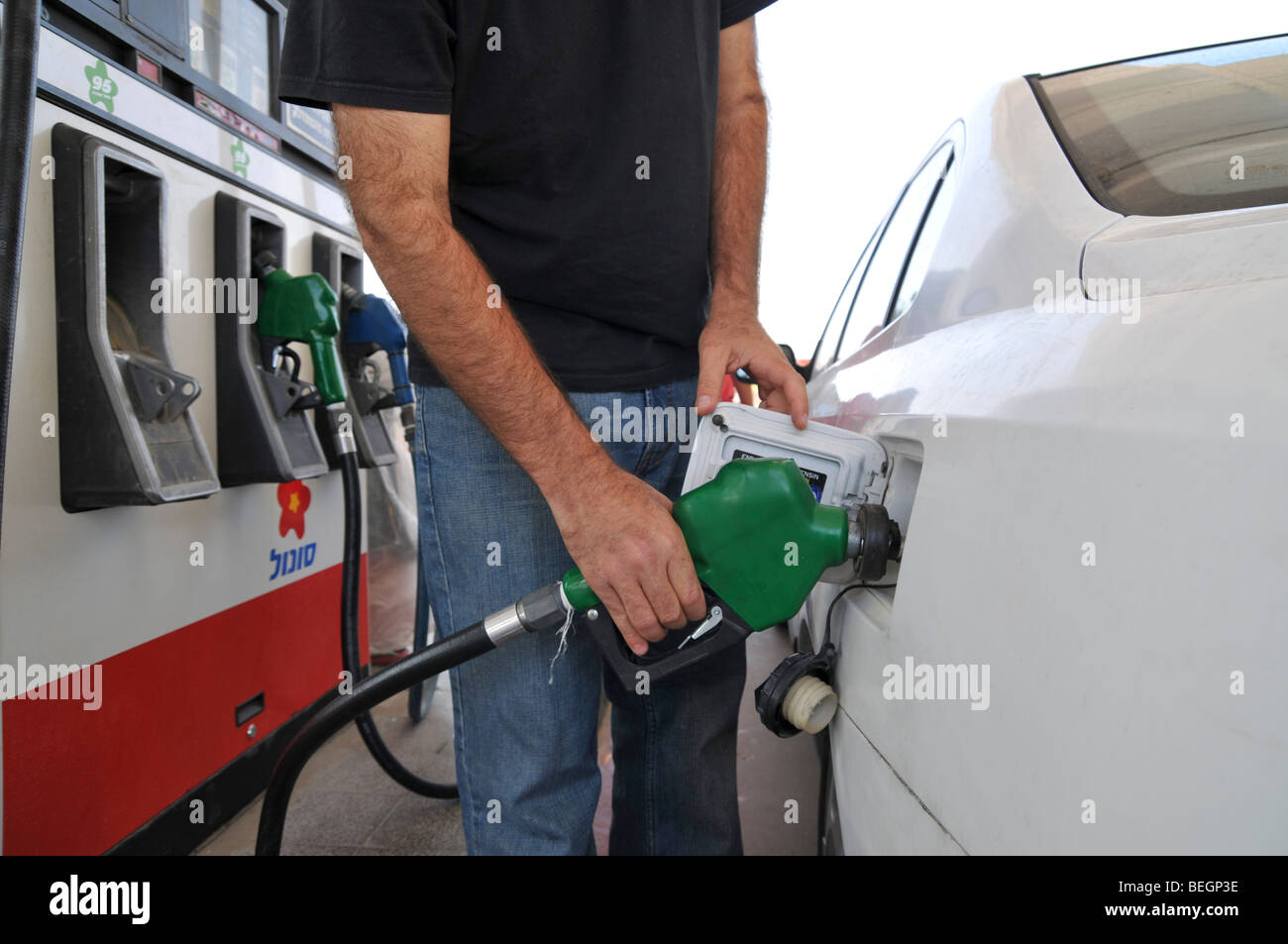 Petrol Station man refuels car with unleaded petrol Stock Photo
