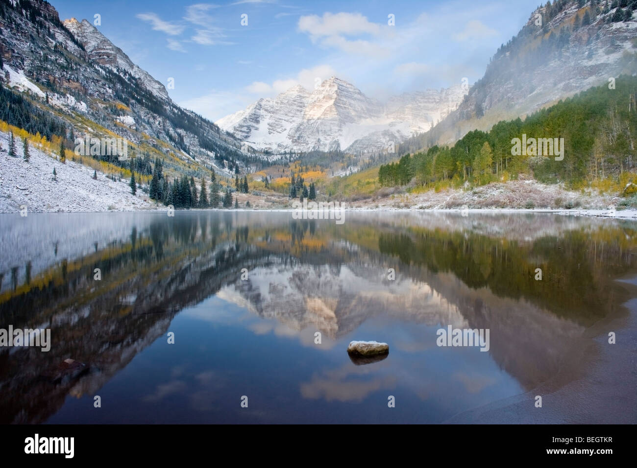 Classic Maroon Bells Reflection during fall or winter with frozen lake, ice and snow Stock Photo