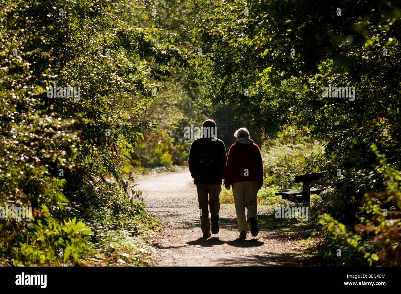 A man and a woman walking along a path in Thorndon Park in Essex. Photo ...