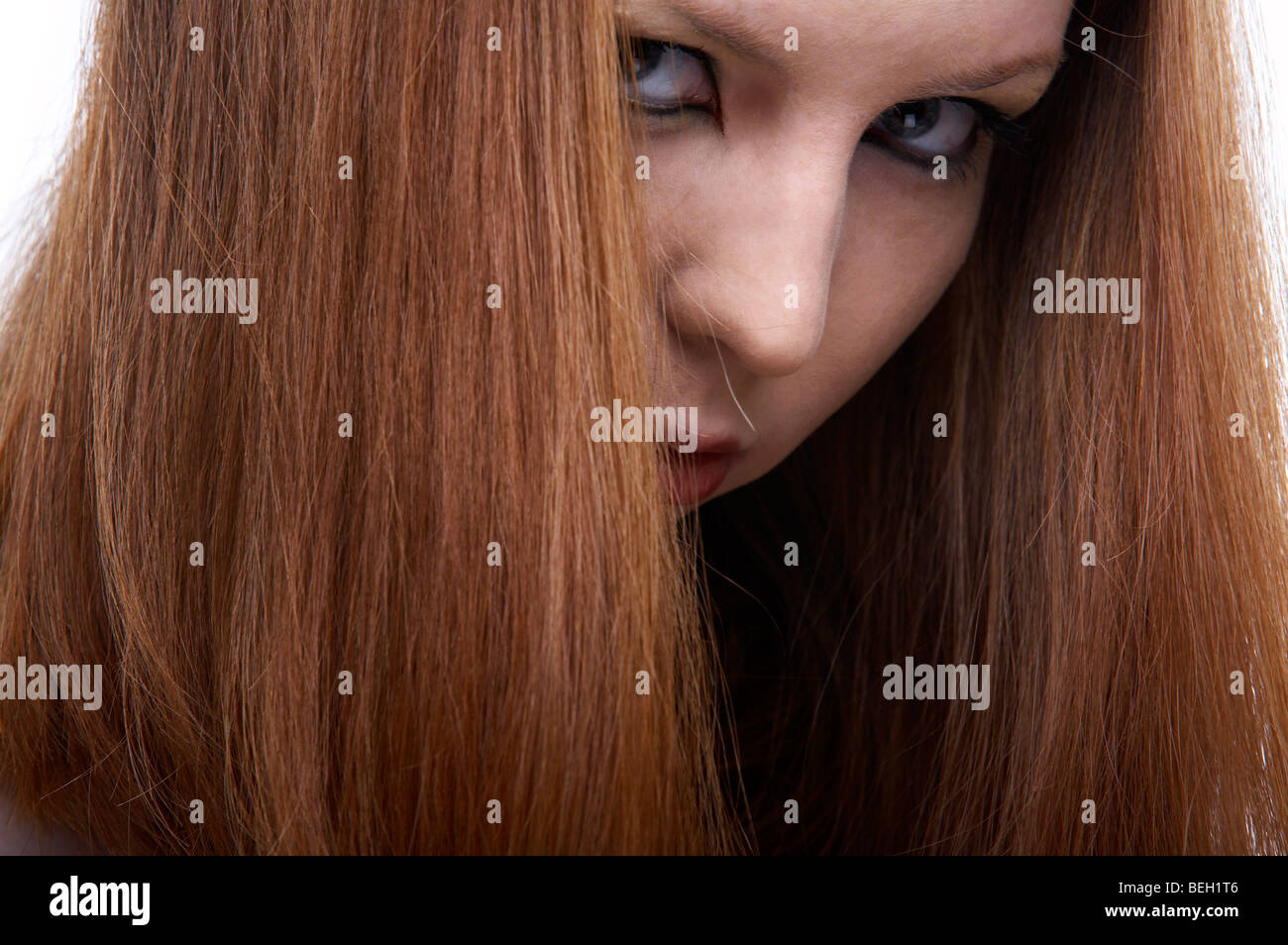 close-up portrait of beautiful redhead pale skinned model turns and looks frowningly Stock Photo
