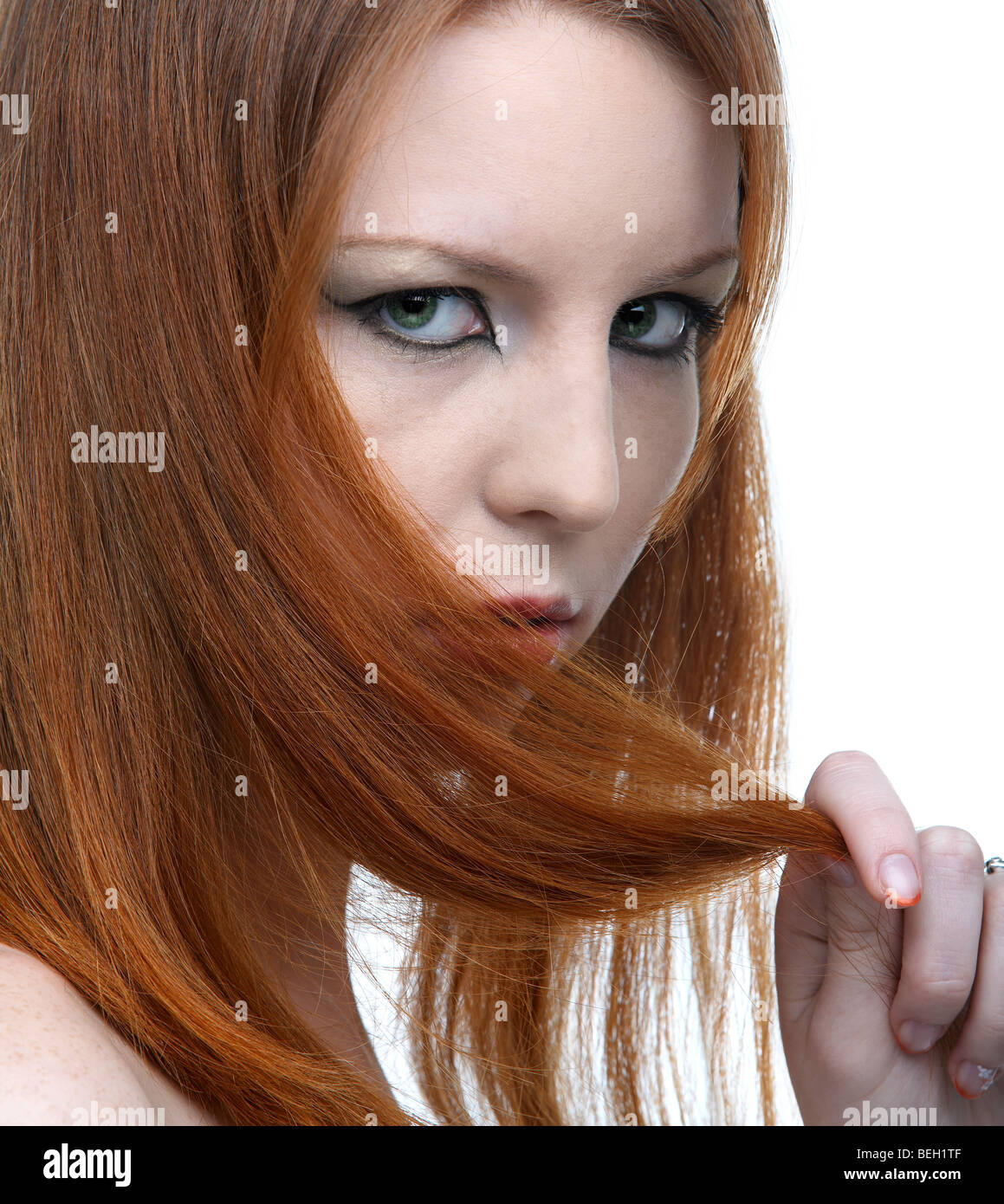 close-up portrait of beautiful redhead pale skinned model hiding her face in hair Stock Photo