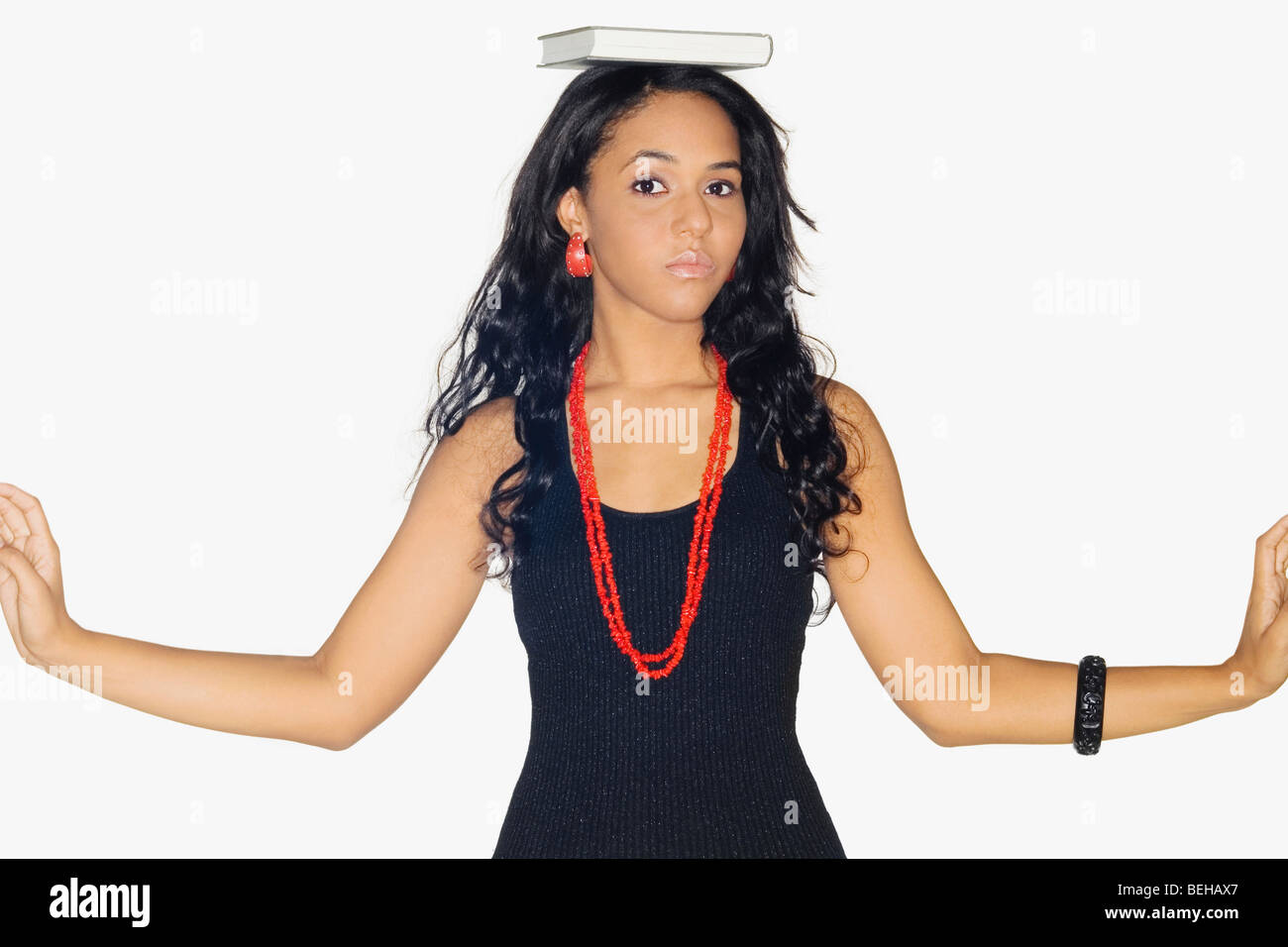 Portrait of a teenage girl with a book on her head Stock Photo - Alamy