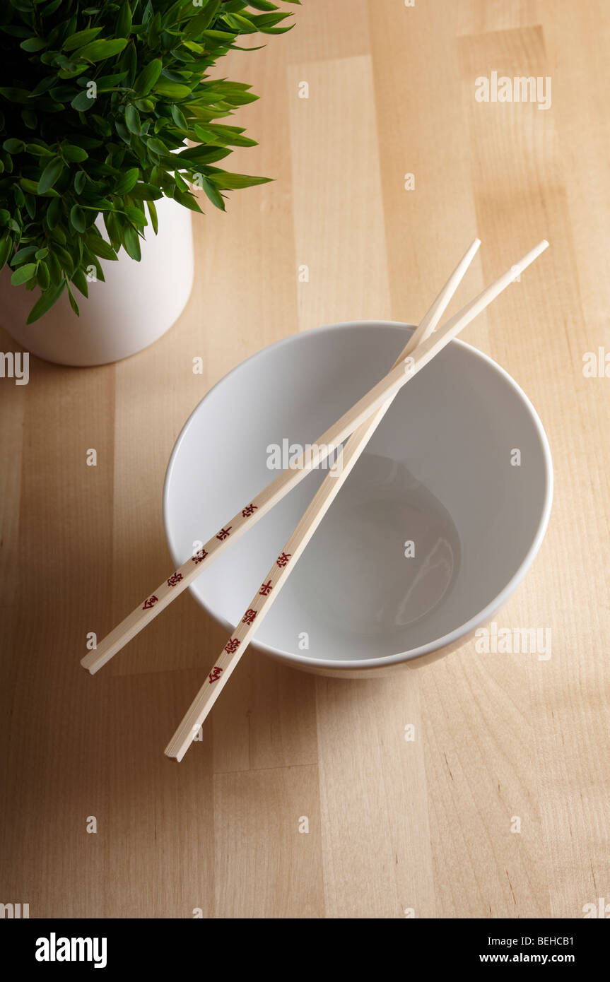 Chopsticks with white bowl and bamboo plant Stock Photo
