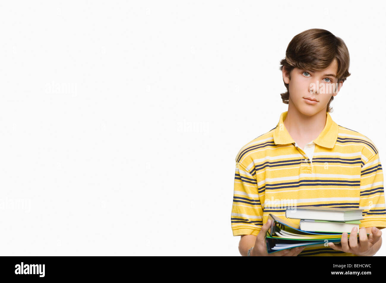 Portrait of a teenage boy holding books and ring binders Stock Photo ...