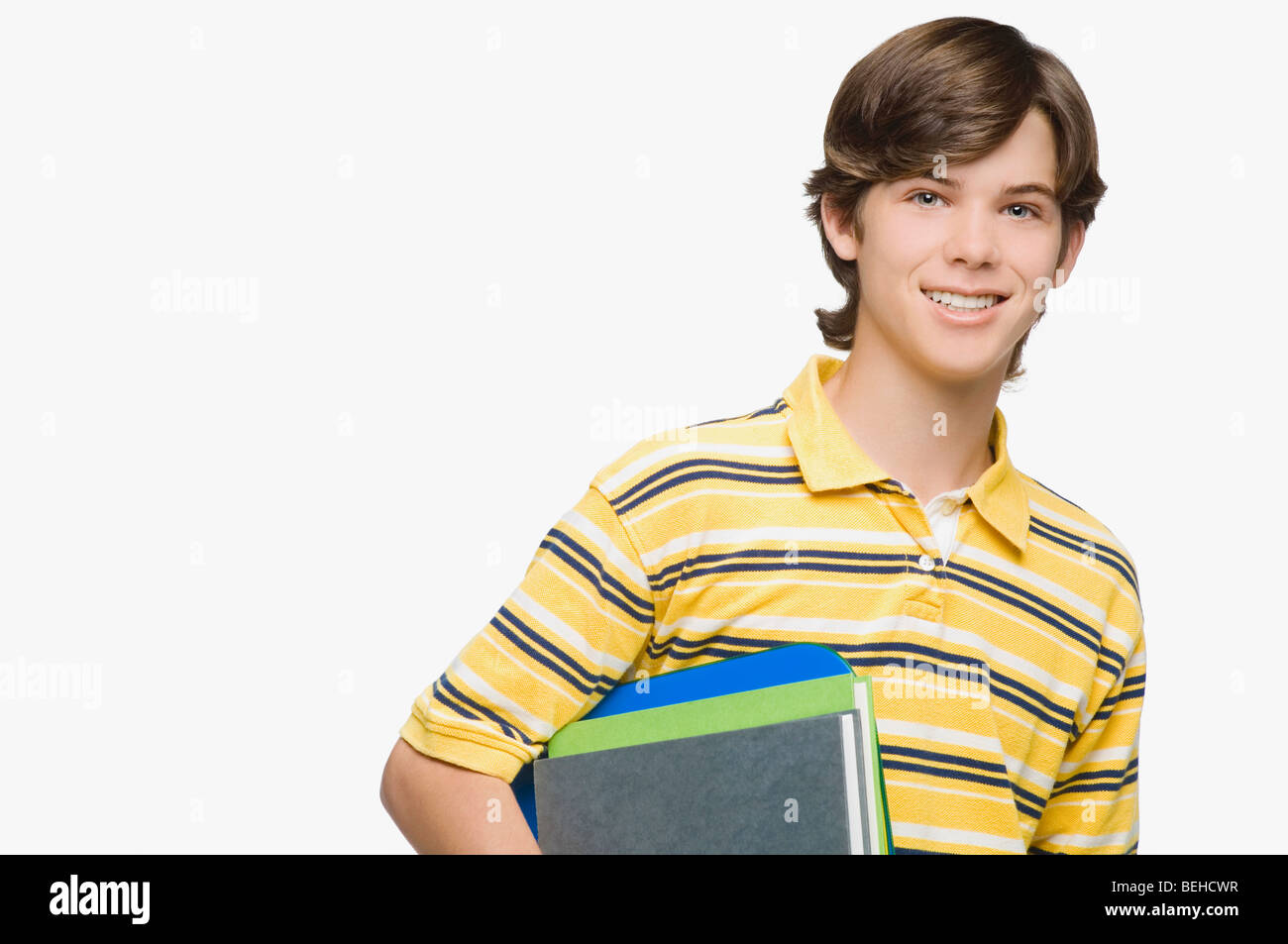 Portrait of a teenage boy holding books and ring binders Stock Photo ...