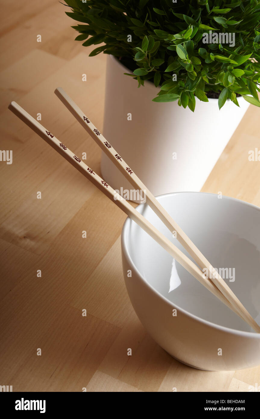 Chopsticks with white bowl and bamboo plant Stock Photo