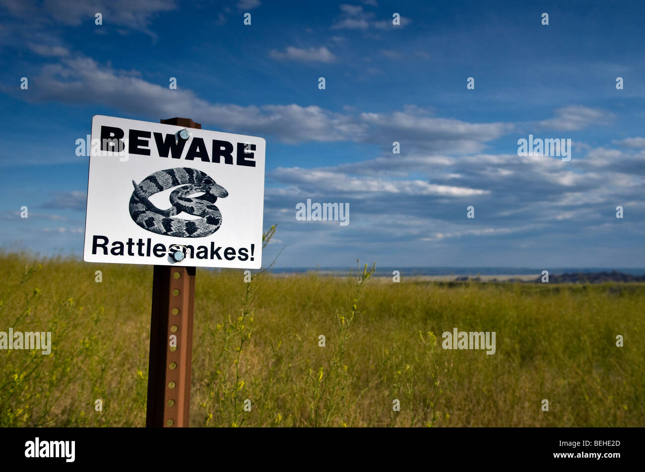 South Dakota,  'beware of rattlesnakes' caution sign in a mid west USA grassland landscape Stock Photo