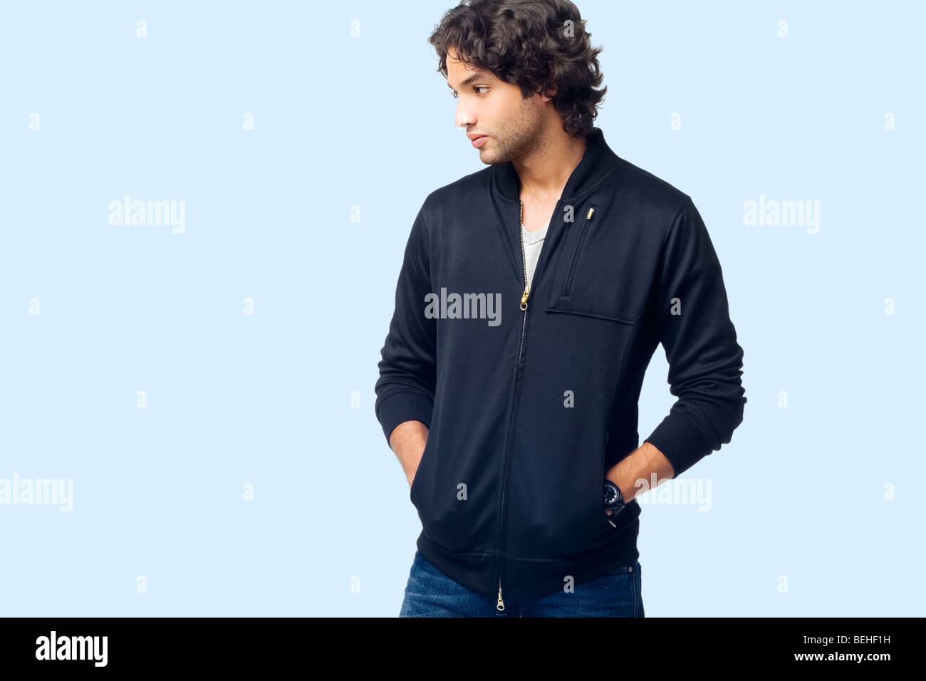 Young man standing with his hands in his pockets Stock Photo - Alamy