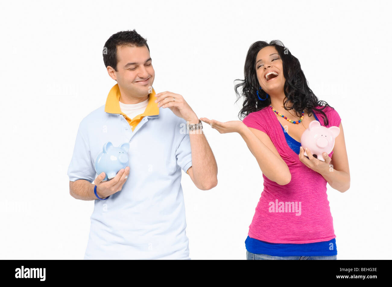 Young couple holding piggy banks and smiling Stock Photo - Alamy