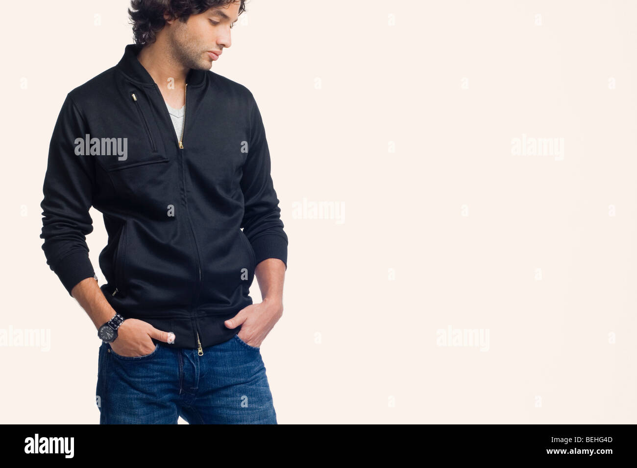 Young man standing with his hands in his pockets Stock Photo - Alamy