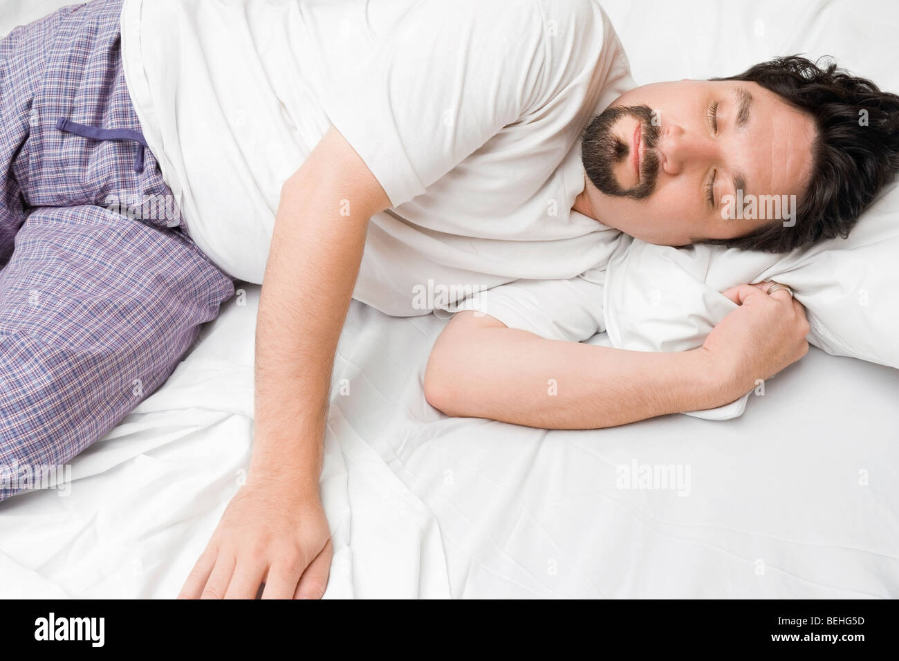 Mid adult man sleeping on the bed Stock Photo - Alamy