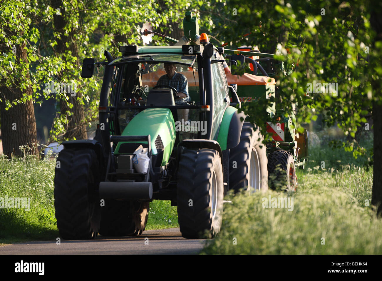Tractor drives on way, Belgium Stock Photo
