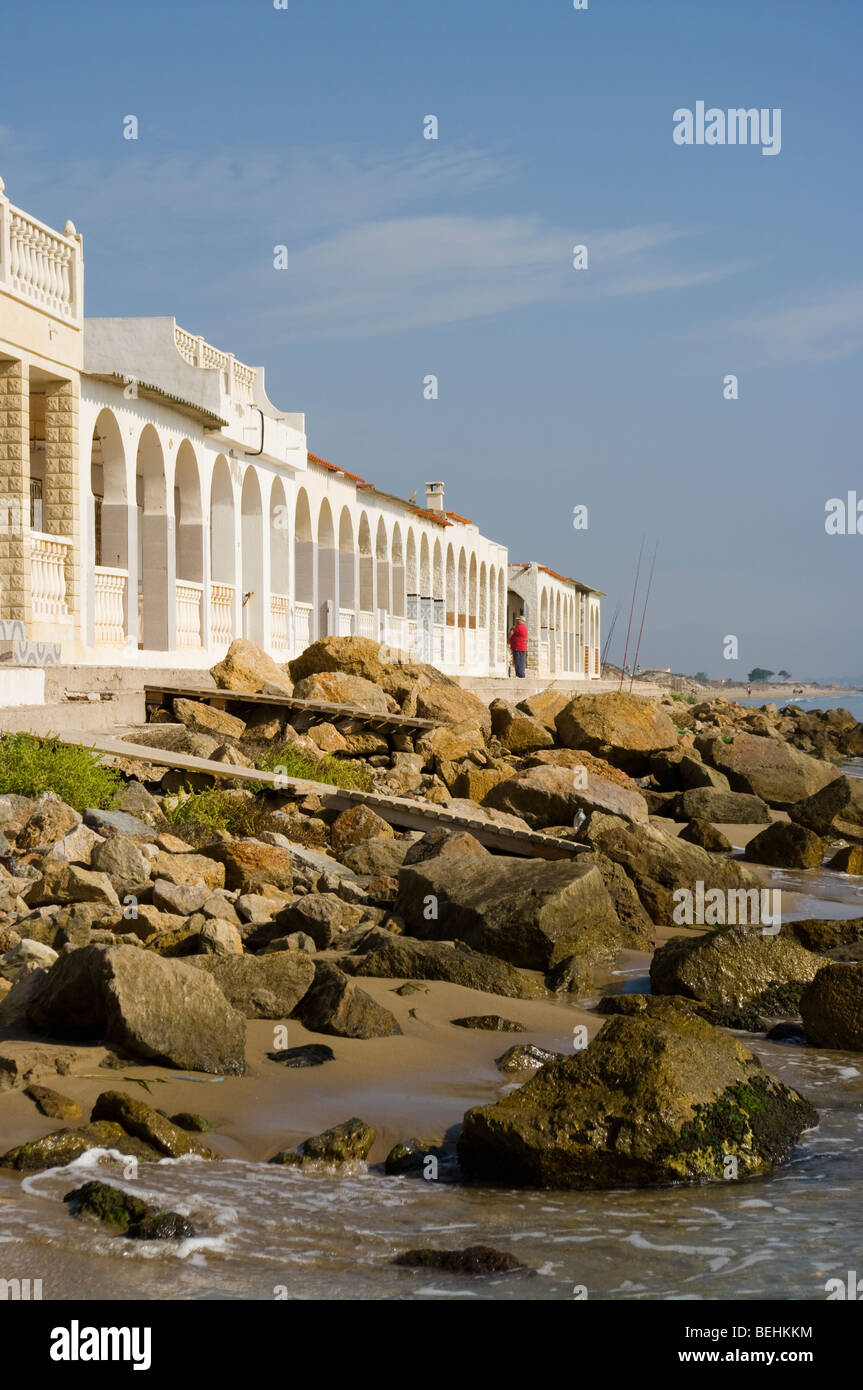 Arched Frontage Of Beachfront Holiday Villas Playa Del Pinet La Marina Spain With A Rocky Foreshore Stock Photo