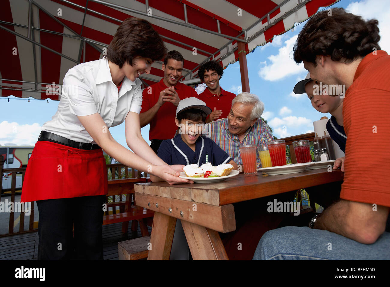 Boy celebrating his birthday with his family in a restaurant Stock
