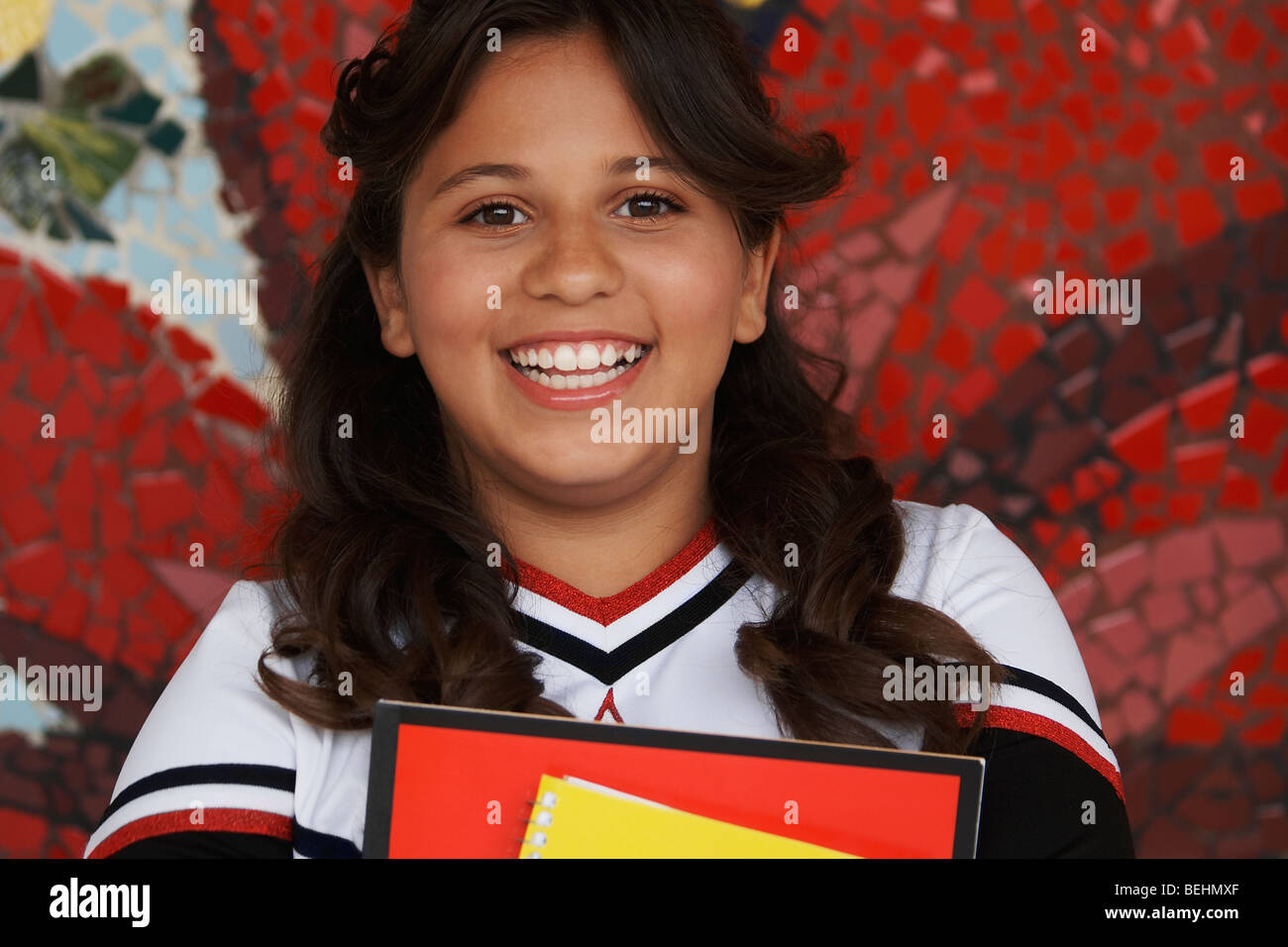 Portrait of a girl holding books and smiling Stock Photo - Alamy