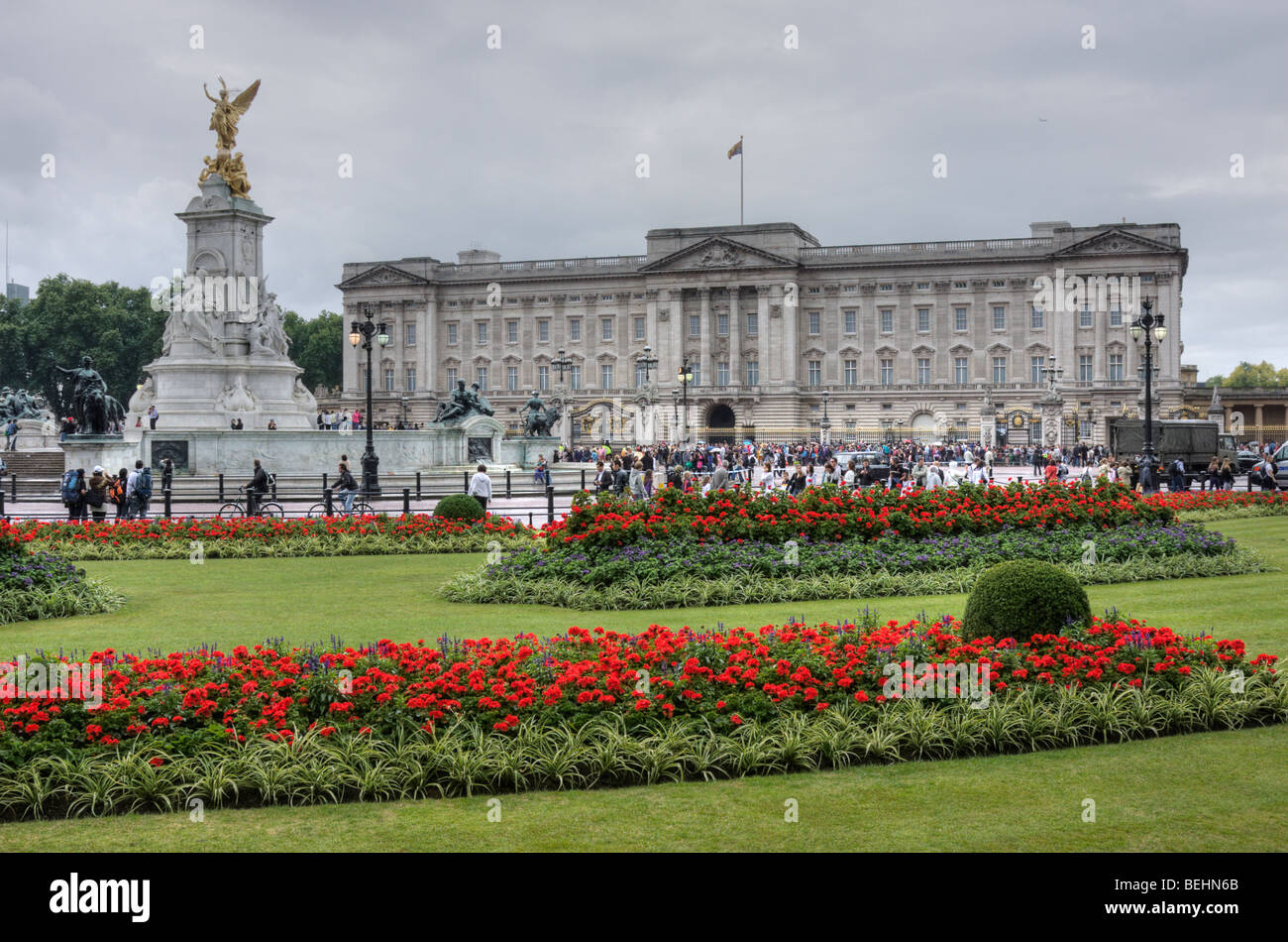 Buckingham Palace on a cloudy summer day, with flowers in a landscaped garden in front. Stock Photo