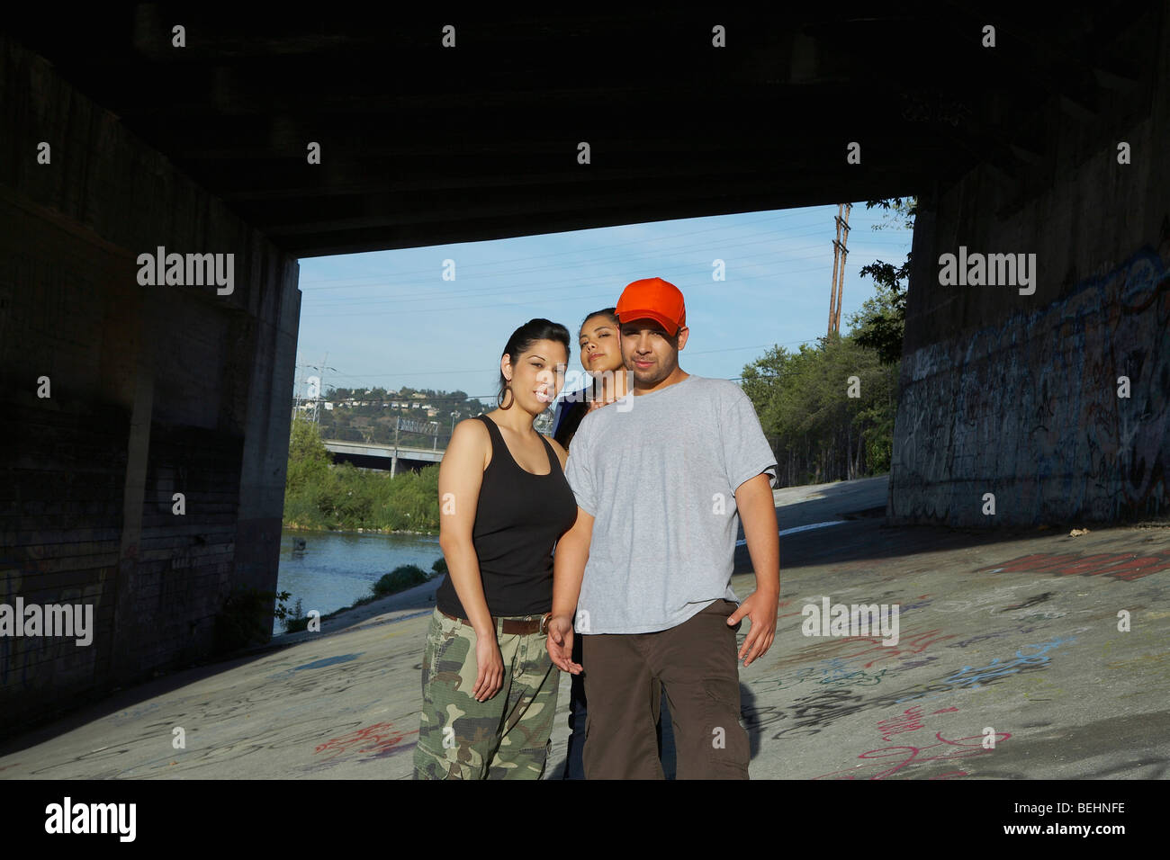 Portrait of a young man with two young women posing Stock Photo - Alamy
