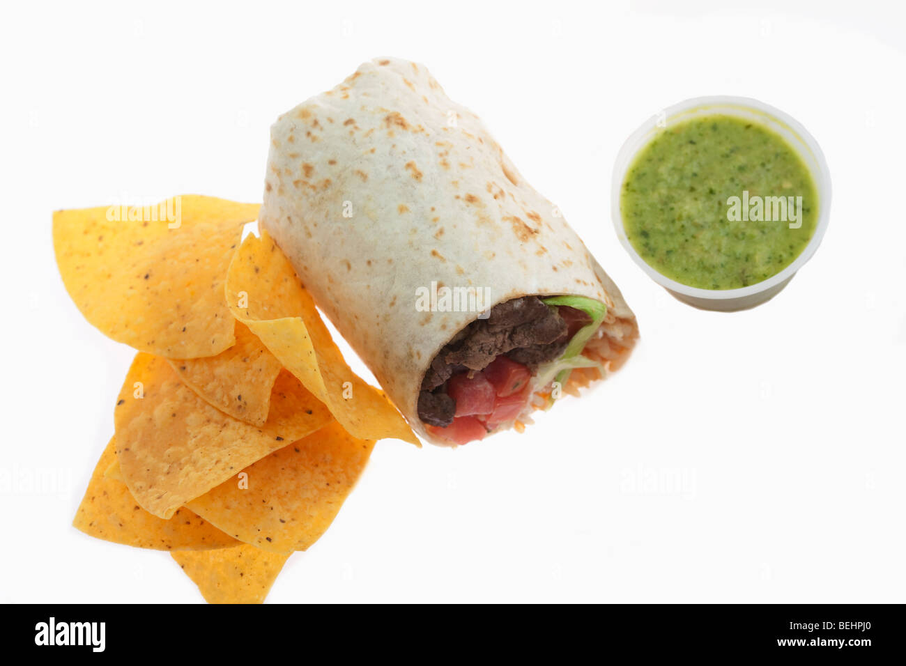 Close-up of a beef burrito with tortilla chips and salsa verde Stock Photo