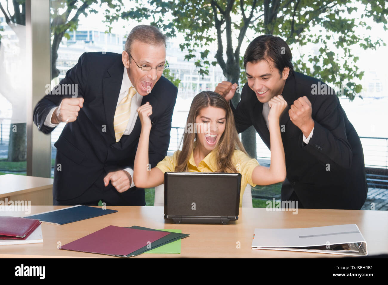 Business executives looking excited in front of a laptop Stock Photo