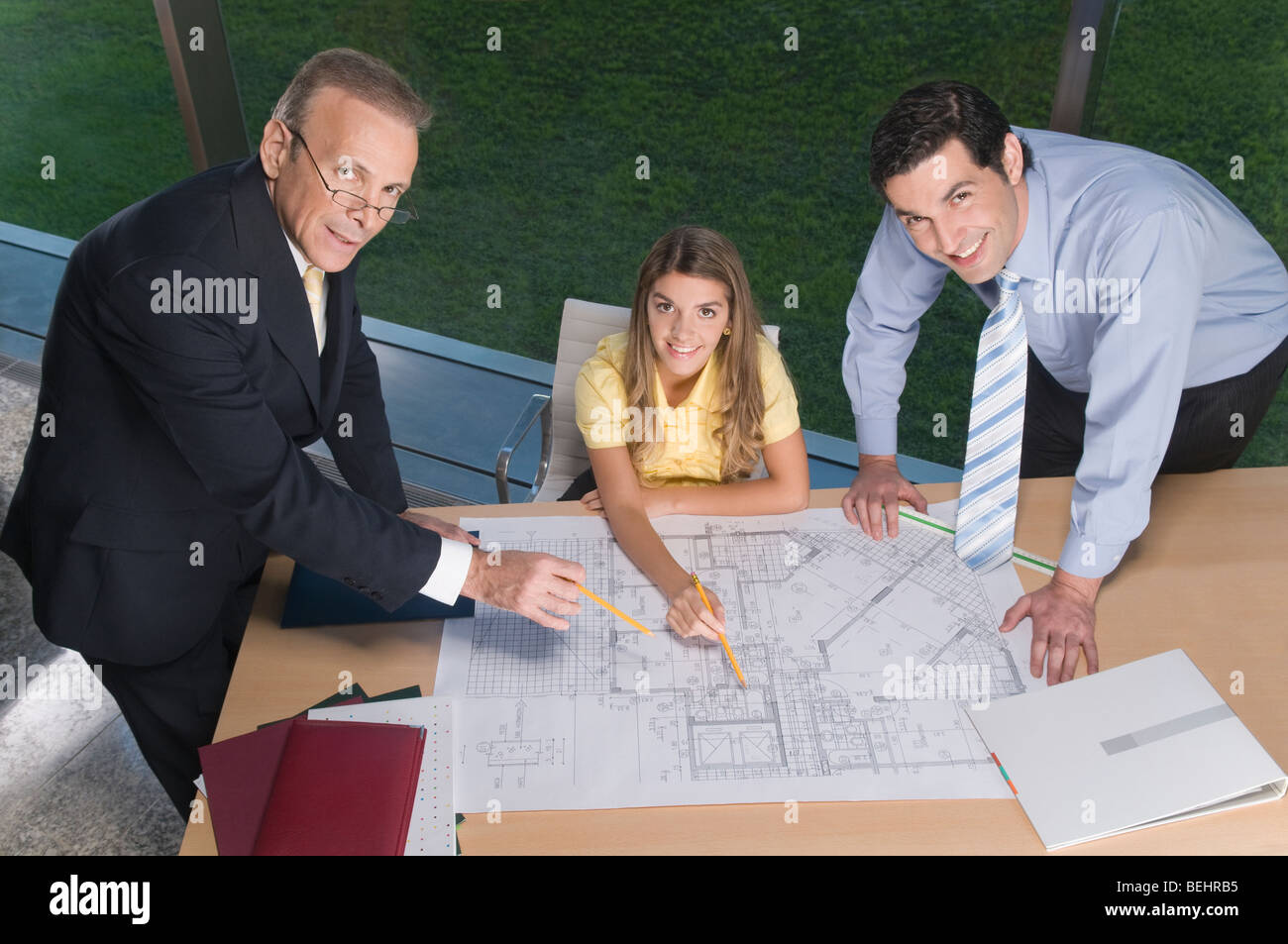 Portrait of business executives discussing a blueprint in an office Stock Photo