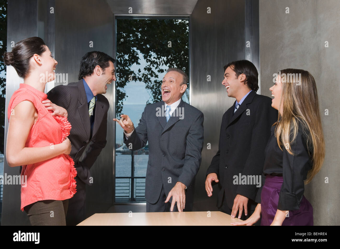 Business executives laughing in a conference room Stock Photo