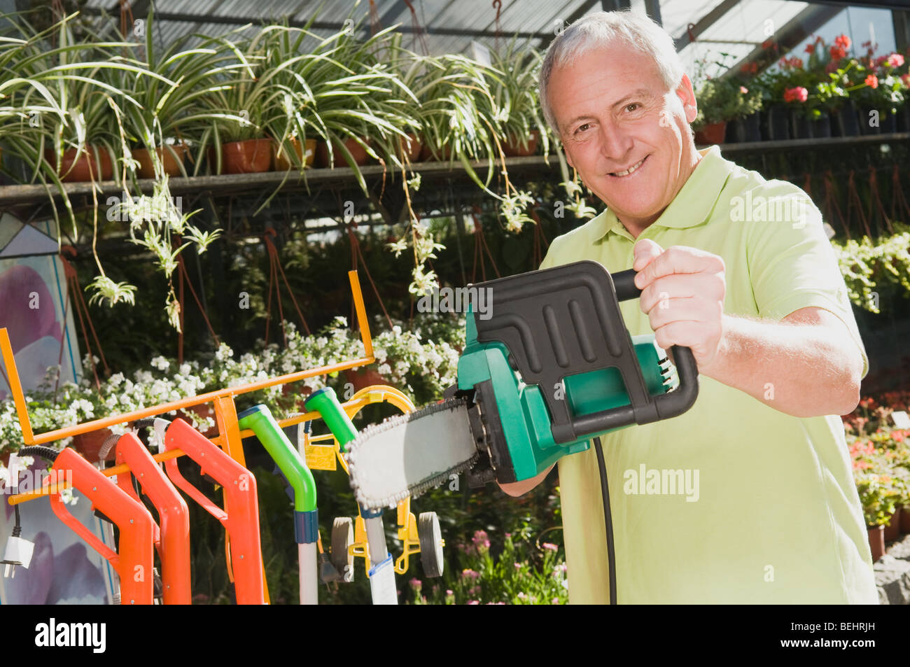 Man holding a chainsaw in a hardware store Stock Photo