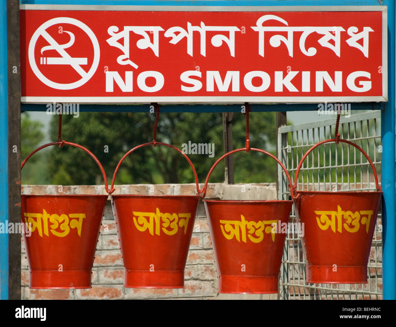 Buckets for extinguishing fires and a no smoking sign to warn customers at a Bangladeshi gas station. Stock Photo