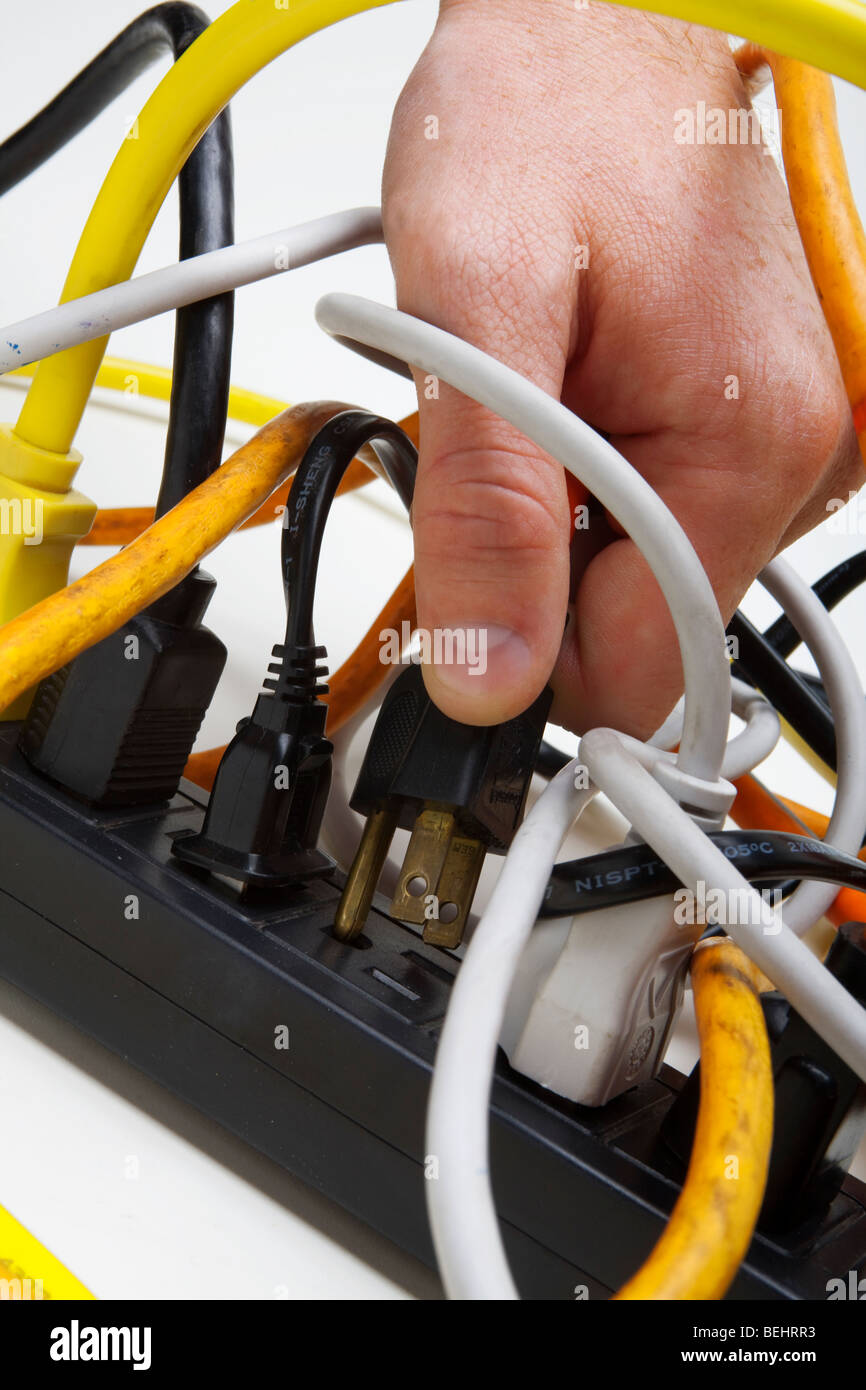 Plugging a cord into a tangled surge protector Stock Photo Alamy