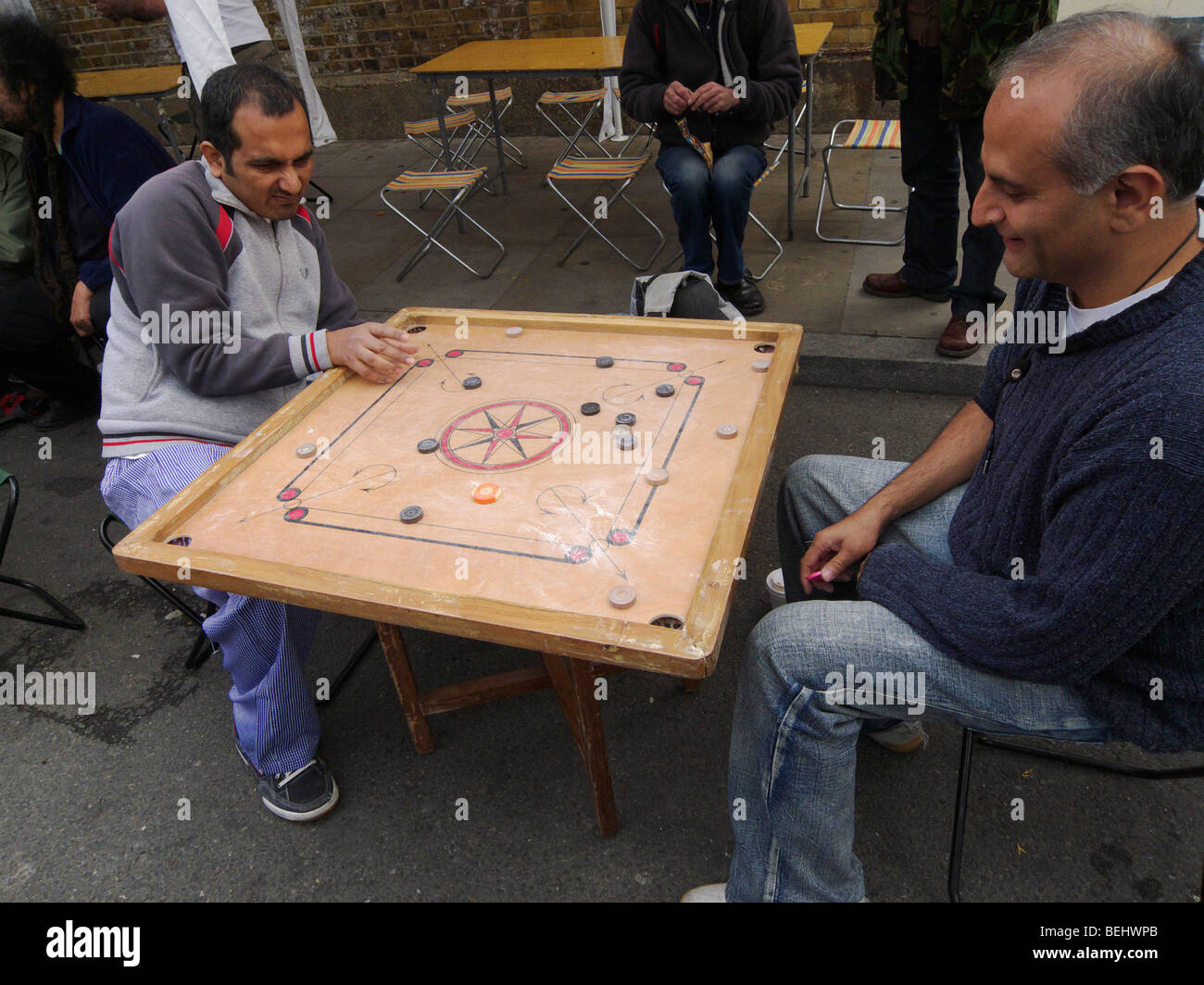 Playing the tabletop game Carrom in Brick Lane, London, England Stock