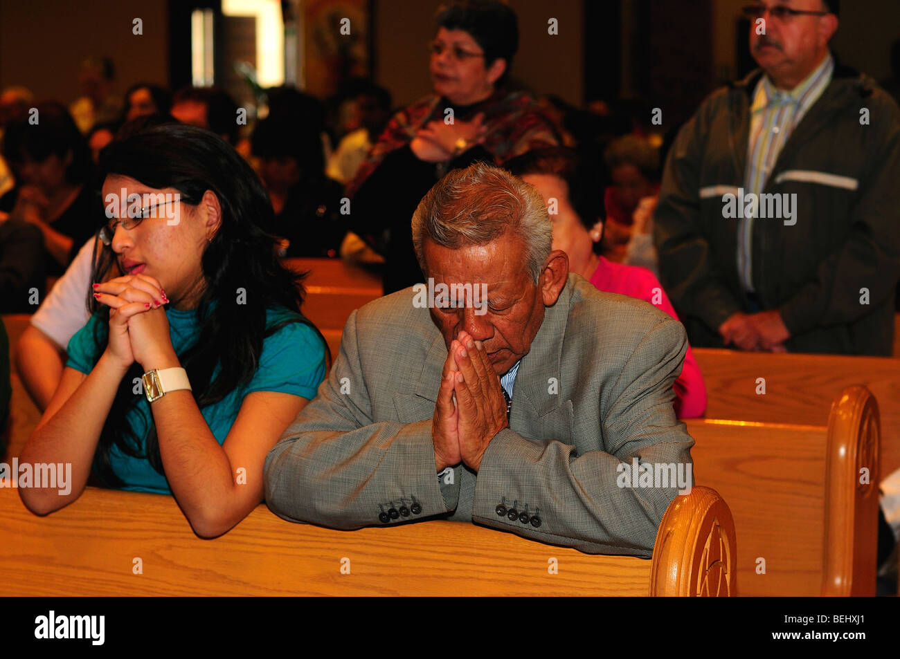 A family prays at a Catholic church. Stock Photo